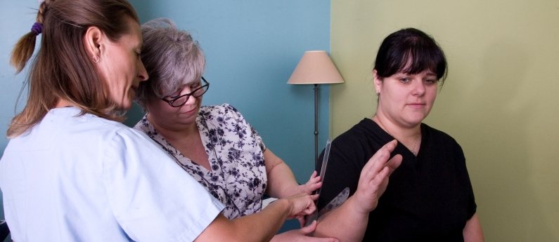 A woman having her arm examined. Are you interested in taking a registered massage therapy courses online? Call MH Vicars.